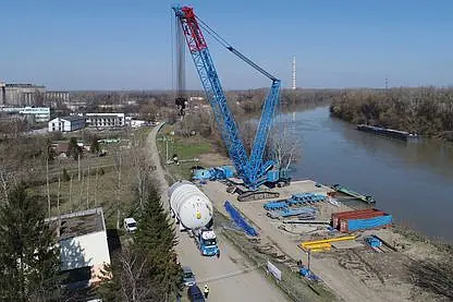 © János Szalóki Umschlag eines großen Behälters mittels Raupenkran von einem Binnenschiff