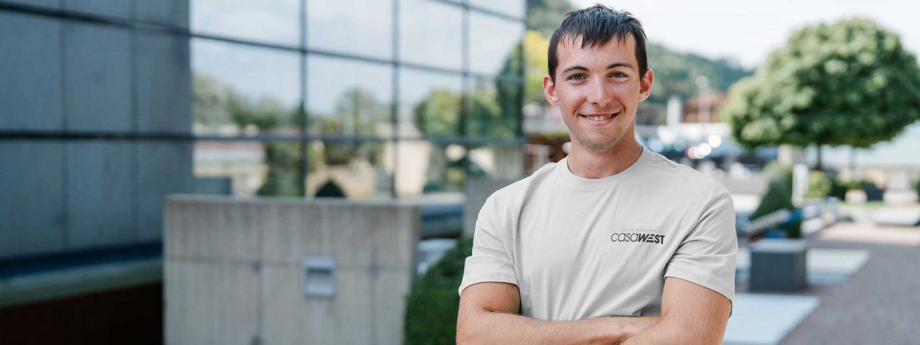 Lehre als Steinmetz: ein Lehrling lächelt am Firmengelädne von Casawest in die Kamera