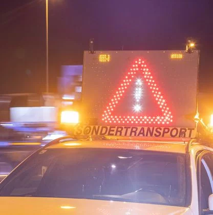 Beschilderung eines Schwertransport bei Nacht