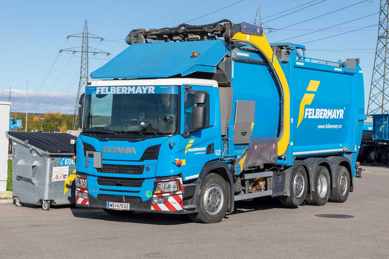 Felbermayr-Lkw für die Entsorgung von unterschiedlichen Abfällen. Rechts daneben steht ein Umleercontainer.  