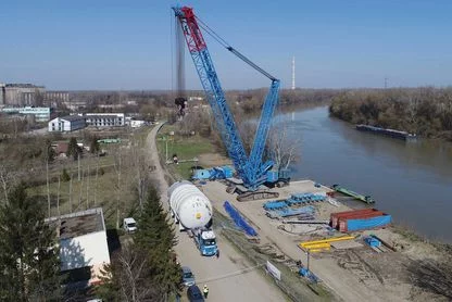 Umschlag eines großen Behälters mittels Raupenkran von einem Binnenschiff