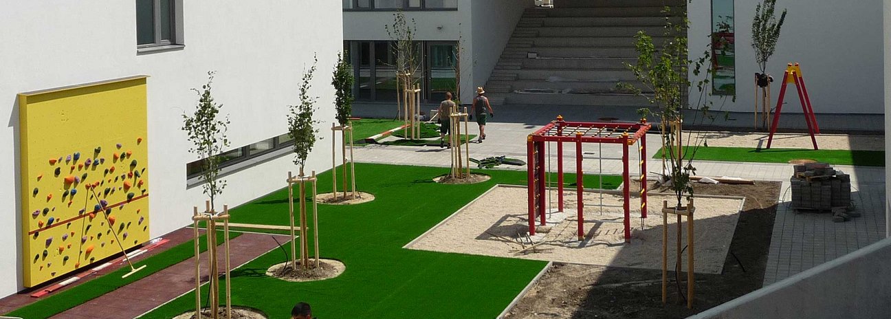 Platz mit Spielgeräten und Kunstrasen