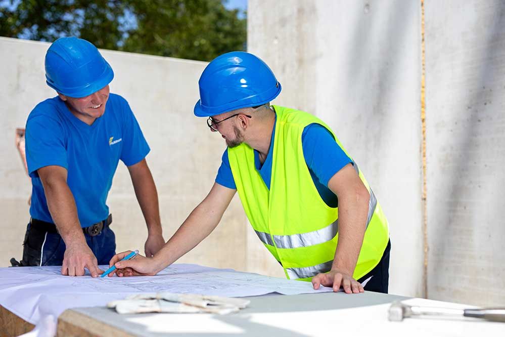 Lehre als Tiefbauer bei Felbermayr: 2 Männer besprechen den Bauplan für das nächste Projekt