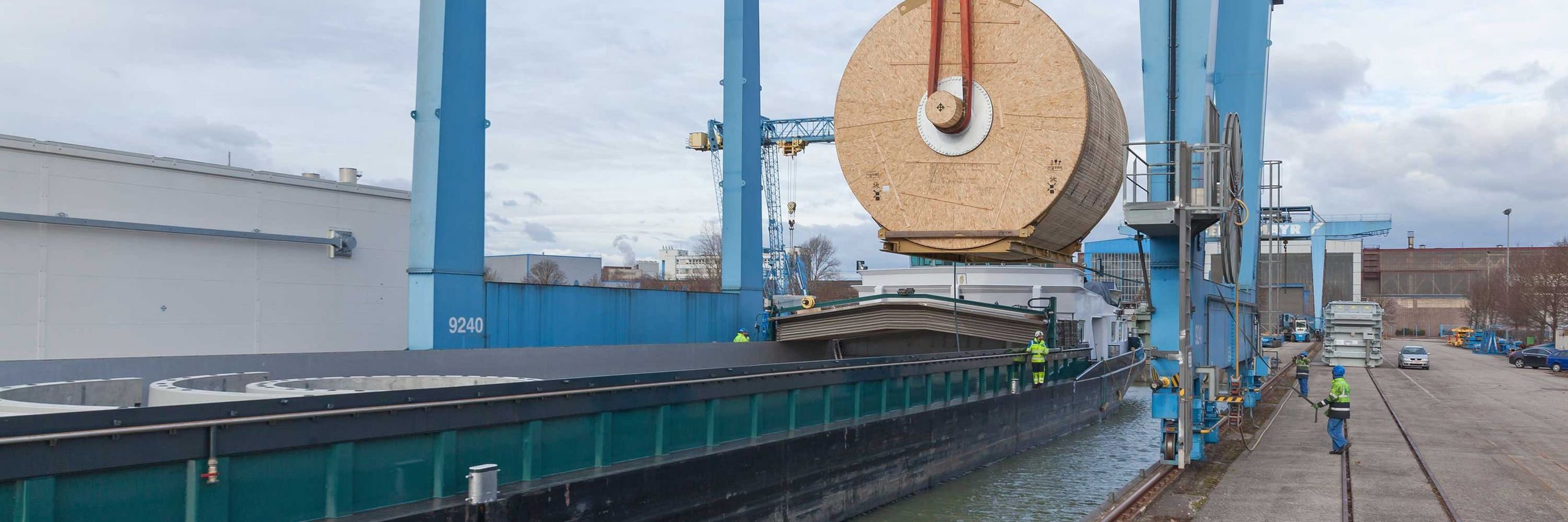 Verladung eines Zylinders durch einen Hafenkran auf ein Binnenschiff